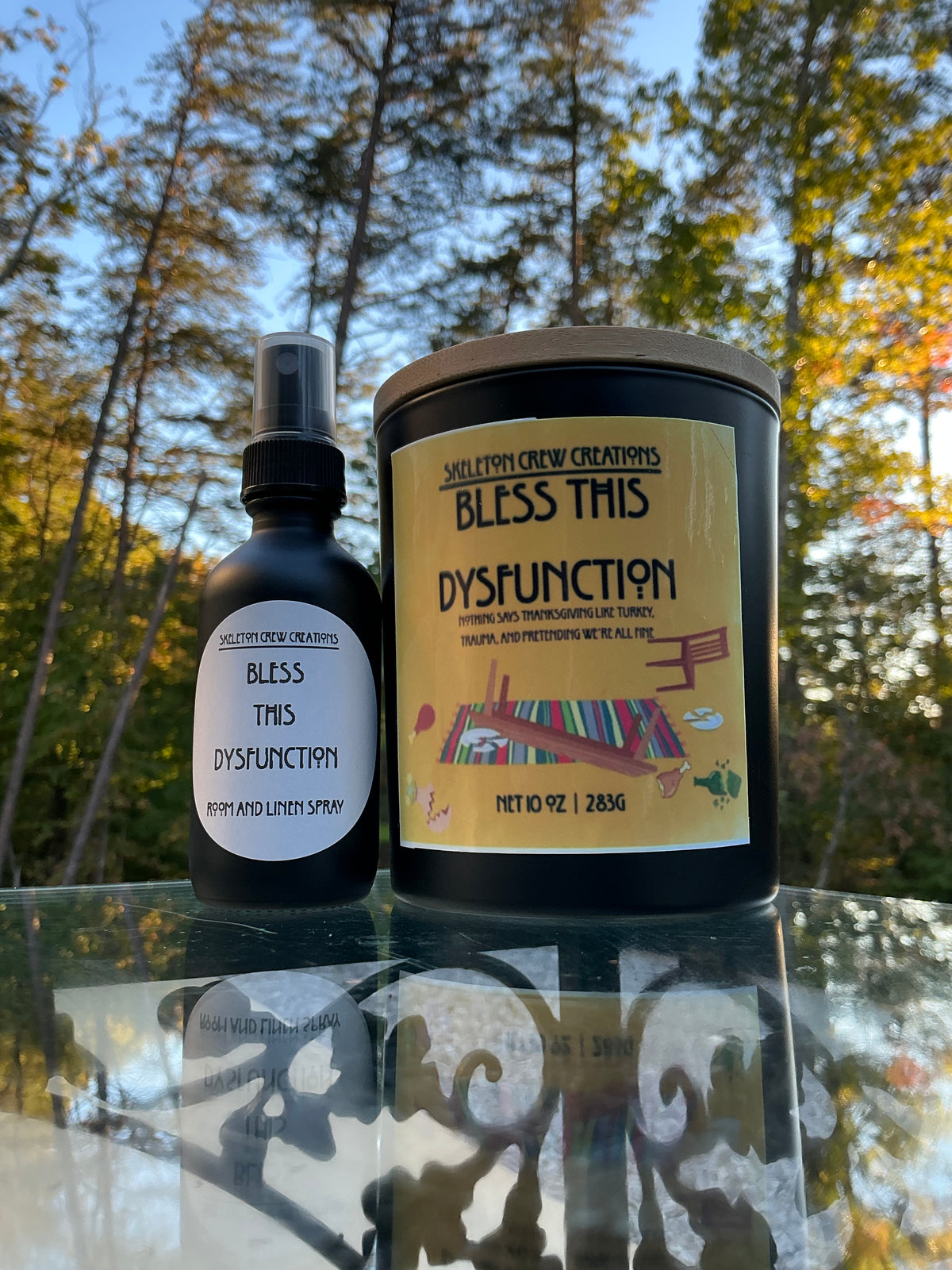 Close view of the Bless This Dysfunction candle label and the matching room spray