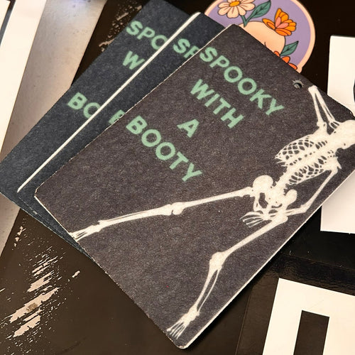Close view of three SPOOKY WITH A BOOTY car air fresheners with a dancing skeleton design